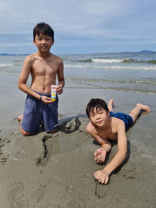 two boys at the beach with étoile i sun cream